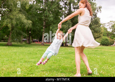 Felice madre giocando con la bambina al parco di estate Foto Stock