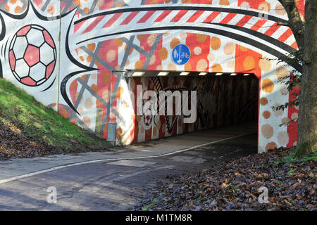 Pubblico sottopassaggio vicino a Crawley Town Football Stadium decorata con un disegno di calcio, Crawley, West Sussex, in Inghilterra, Regno Unito. Foto Stock