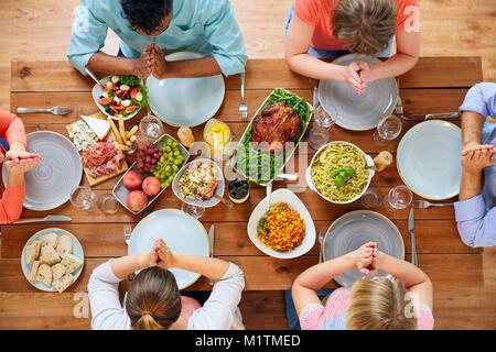 Gruppo di persone a tavola pregare prima del pasto Foto Stock