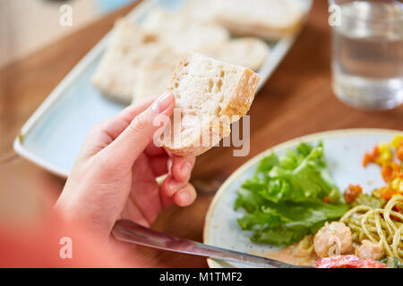 Mano di donna che mantiene il pezzo di pane Foto Stock