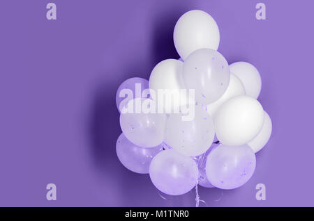Bianco palloncini di elio su ultra sfondo viola Foto Stock