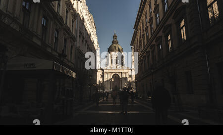 Una foto scattata nella città di Budapest. Una bellissima strada livello shot della magnifica St Stephens Basilica. Prese durante l'incantevole azzurro del cielo. Foto Stock