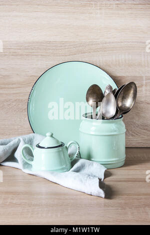 Il turchese stoviglie, posate, stoviglie e utensili da roba su piano in legno. Cucina ancora la vita come sfondo per il design. Immagine con copia spazio. Foto Stock