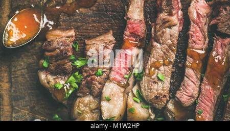 Flat-lay della bistecca grigliata di carne di manzo tagliata a pezzi Foto Stock