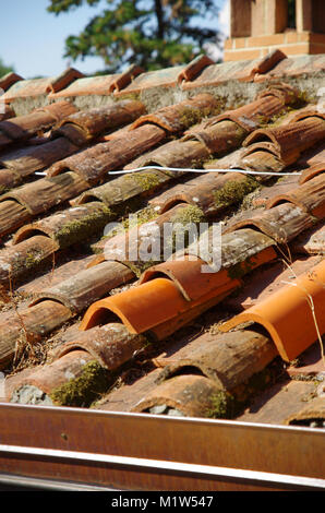 Tetto con vecchi e piastrelle rotte sostituite con nuove tessere Foto Stock