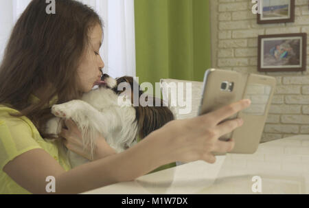 Felice ragazza adolescente facendo selfie con il suo cane Foto Stock