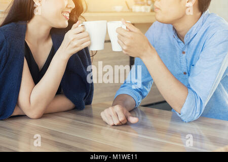 Felice coppia giovane gente di incontro rilassante e bere un tè o un caffè nella caffetteria. Cerca happy dating. Foto Stock
