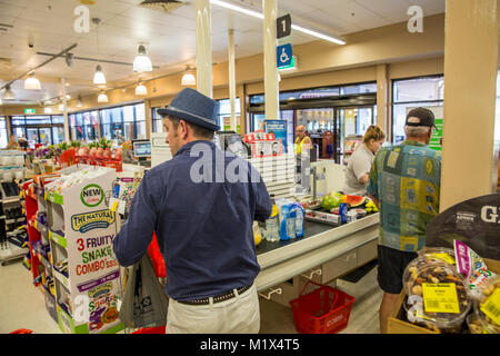 Uomini alla cassa che acquistano generi alimentari in un supermercato Coles nel Queensland, Australia Foto Stock