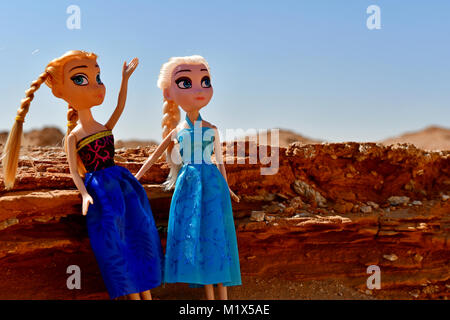 Barbie ragazze vestito di rosso e blu sono in posa per la modellazione di foto nel deserto rocce sulla posizione Foto Stock