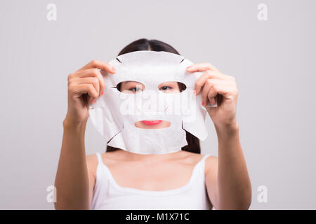 La pelle del viso cura. Donna con un panno maschera idratante sul suo viso Foto Stock