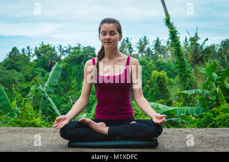 La donna medita di Yoga asana Padmasana Foto Stock