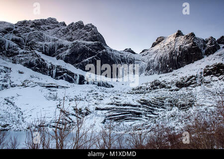 Montagne coperte di neve sulla strada per Nusfjord, Flakstadøya Isole Lofoten in Norvegia Foto Stock