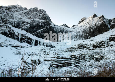 Montagne coperte di neve sulla strada per Nusfjord, Flakstadøya Isole Lofoten in Norvegia Foto Stock