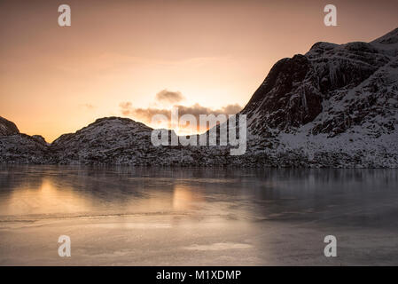 Montagne coperte di neve sulla strada per Nusfjord, Flakstadøya Isole Lofoten in Norvegia Foto Stock