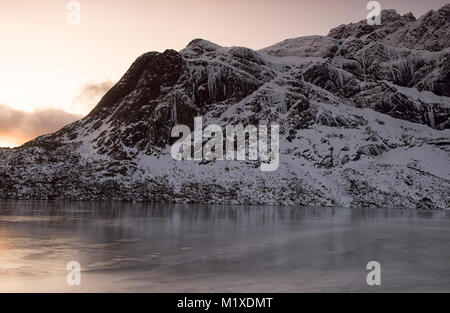 Montagne coperte di neve sulla strada per Nusfjord, Flakstadøya Isole Lofoten in Norvegia Foto Stock