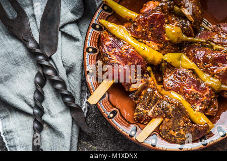 Gustosi spiedini di carne con salsiccia per pizza o peperoncino per grill o barbecue sul tavolo da cucina con acciaio inossidabile , vista superiore, vicino fino Foto Stock