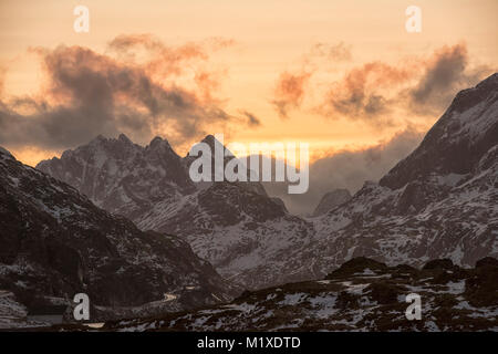 La luce del tramonto nelle montagne che circondano il villaggio di pescatori di Ramberg nelle Isole Lofoten in Norvegia Foto Stock