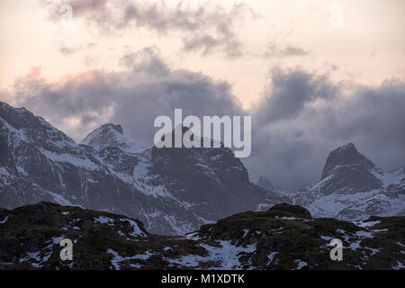 La luce del tramonto nelle montagne che circondano il villaggio di pescatori di Ramberg nelle Isole Lofoten in Norvegia Foto Stock