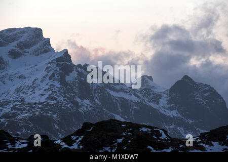 La luce del tramonto nelle montagne che circondano il villaggio di pescatori di Ramberg nelle Isole Lofoten in Norvegia Foto Stock