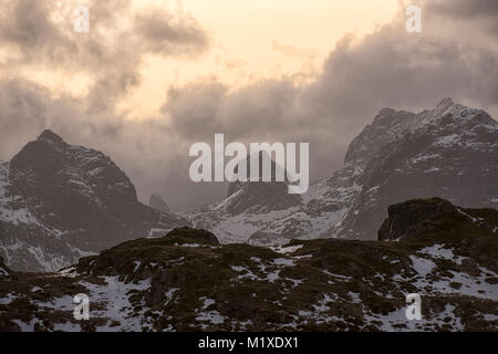 La luce del tramonto nelle montagne che circondano il villaggio di pescatori di Ramberg nelle Isole Lofoten in Norvegia Foto Stock