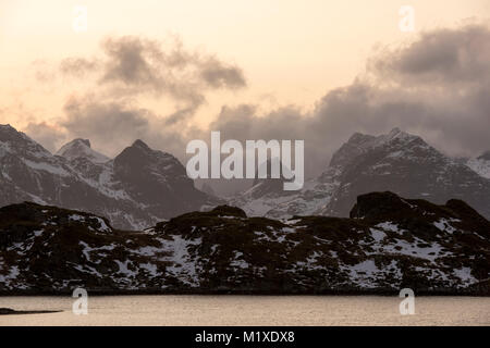 La luce del tramonto nelle montagne che circondano il villaggio di pescatori di Ramberg nelle Isole Lofoten in Norvegia Foto Stock