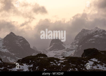 La luce del tramonto nelle montagne che circondano il villaggio di pescatori di Ramberg nelle Isole Lofoten in Norvegia Foto Stock