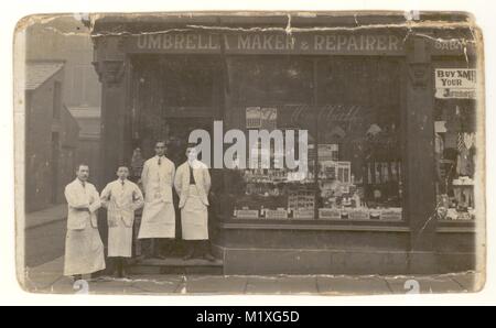 Cartolina originale dei primi anni '1900 dell'ex negozio di ombrelloni, che vendeva articoli per parrucchieri, personale che posa per una fotografia fuori dal negozio, Bolton o Heywood, Greater Manchester, Inghilterra, Regno Unito, circa 1910. Negozio edoardiano. Negozio vittoriano. Foto Stock