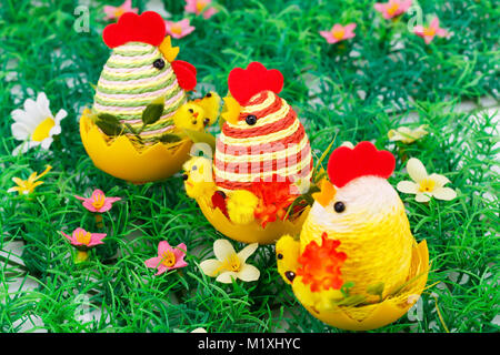 Impostazione di pasqua con le galline e i polli e uova nel nido di erba. Foto Stock