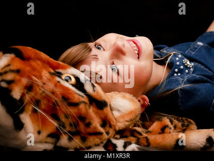 Sullo sfondo nero del leopard si trova un grazioso baby e sorridente Foto Stock