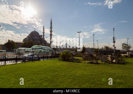 Istanbul - Turchia, Ottobre 09, 2015: Yeni Cami vista da Istanbul durante la serata con la luce di retromarcia e l'erba verde Foto Stock