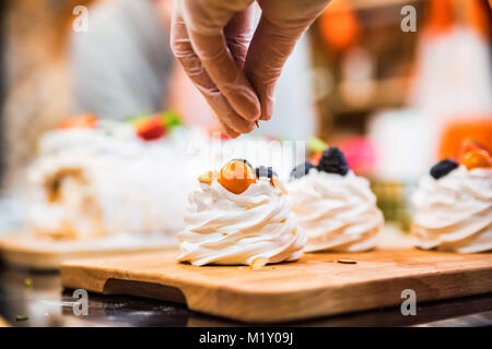 Rendendo la deliziosa torta di meringa con frutti di bosco Foto Stock