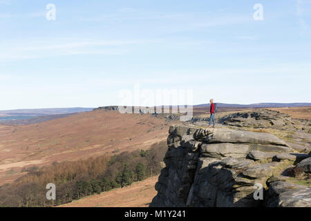 Regno Unito, Derbyshire, Peak District Nationa Park, un viandante sul ciglio della scogliera di bordo Stanage. Foto Stock