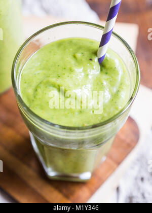 Materie verde spessa frullato vegano in un bicchiere. Foto Stock