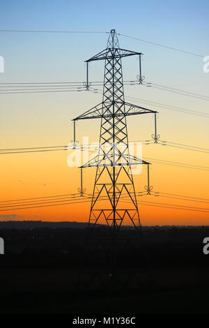 Elettricità pilone di torre con un tramonto colorato, Bedfordshire, England, Regno Unito Foto Stock