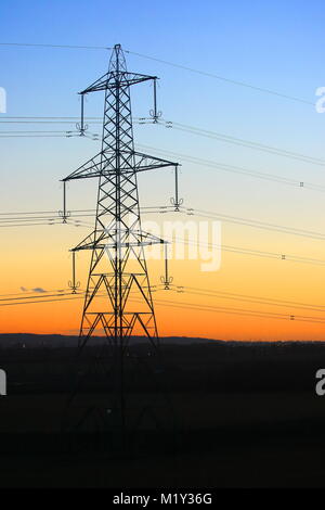 Elettricità pilone di torre con un tramonto colorato, Bedfordshire, England, Regno Unito Foto Stock