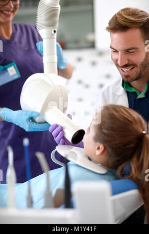 Dentista preparazione tubo a raggi x per rendere x-ray riprese dentale al paziente giovane Foto Stock