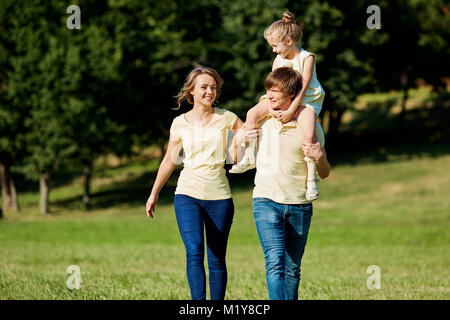 La famiglia felice passeggiate nel parco in estate Foto Stock