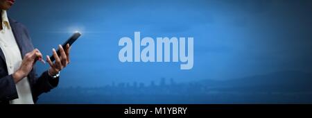 Mano che tiene il telefono con sfondo blu Foto Stock