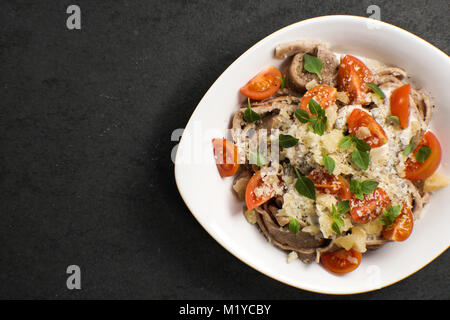 La pasta italiana con il formaggio e ciliegia in una piastra di ceramica in orizzontale Foto Stock