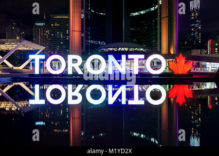 Il Toronto PanAm segno illuminato e Toronto City Hall riflette in acqua a Nathan Phillips Square di notte, Toronto, Ontario, Canada Foto Stock