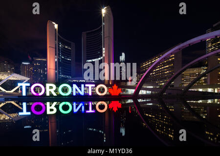 Il Toronto PanAm segno illuminato e Toronto City Hall riflette in acqua a Nathan Phillips Square di notte, Toronto, Ontario, Canada Foto Stock