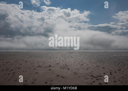 Rottura sole attraverso il vapore sale dalla marea ritirando il Causeway in Lindisfarne Foto Stock