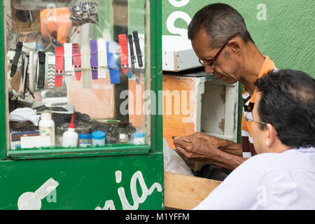 Cartagena, Colombia - Gennaio 24th, 2018: Ritratto di un orologiaio maschio le riparazioni a guardare al Parque de las Flores a Cartagena, Colombia. Foto Stock