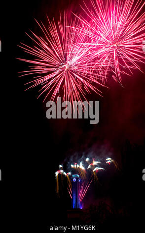 Rosa e argento fuochi d'artificio di Ostrava. Il cielo nero si illumina i fuochi d'artificio in background è un blu orologio a Ostrava municipio nella Repubblica Ceca Foto Stock