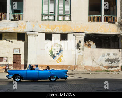 L'Avana, Cuba - 3 Dicembre 2017: blu, antiche e classiche auto in strada della vecchia Avana (Cuba) e sullo sfondo la icona di Che Guevara Foto Stock