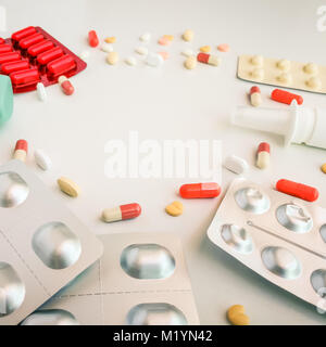 Bianco di medicazione e compresse colorati disposti astratto bianco su sfondo colorato. capsule pillole per il design. Salute, trattamento, scelta lifesty sani Foto Stock
