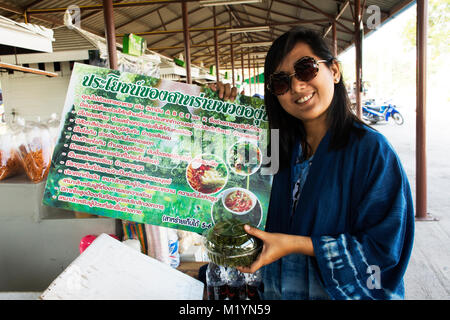 I viaggiatori thai donna acquisto e tenere grandi brand per promuovere il verde di caviale o Umi budo al negozio locale in Laem Phak Bia su Novembre 18, 2017 in Phetchabu Foto Stock