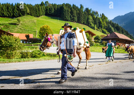 Charmey, Friburgo, Svizzera - 26 Settembre 2015 : gli agricoltori con una mandria di mucche con la transumanza annuale a Charmey vicino a Gruyeres, zona di Friburgo sul Foto Stock