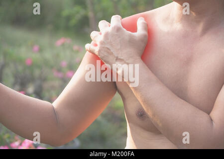 L'uomo soffre di dolore alla spalla. Il dolore acuto in un Muscolo uomo concetto con macchia rossa. Foto Stock