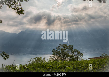 Fascio di luce sopra il lago di Garda in mattinata Foto Stock